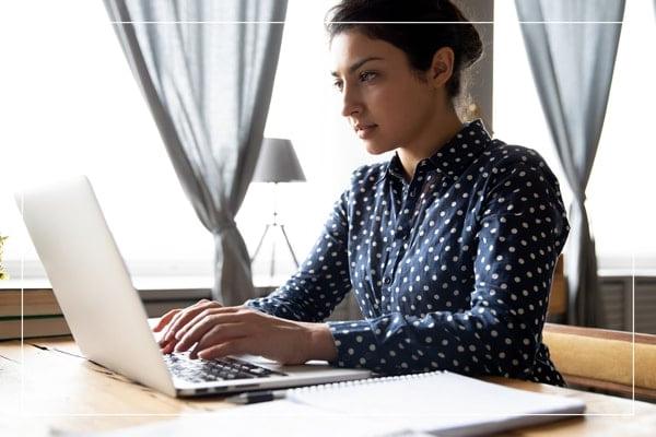 Student sitting at desk, working on laptop